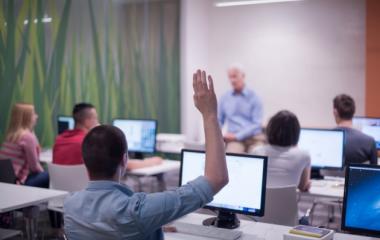 student raises hand in classroom