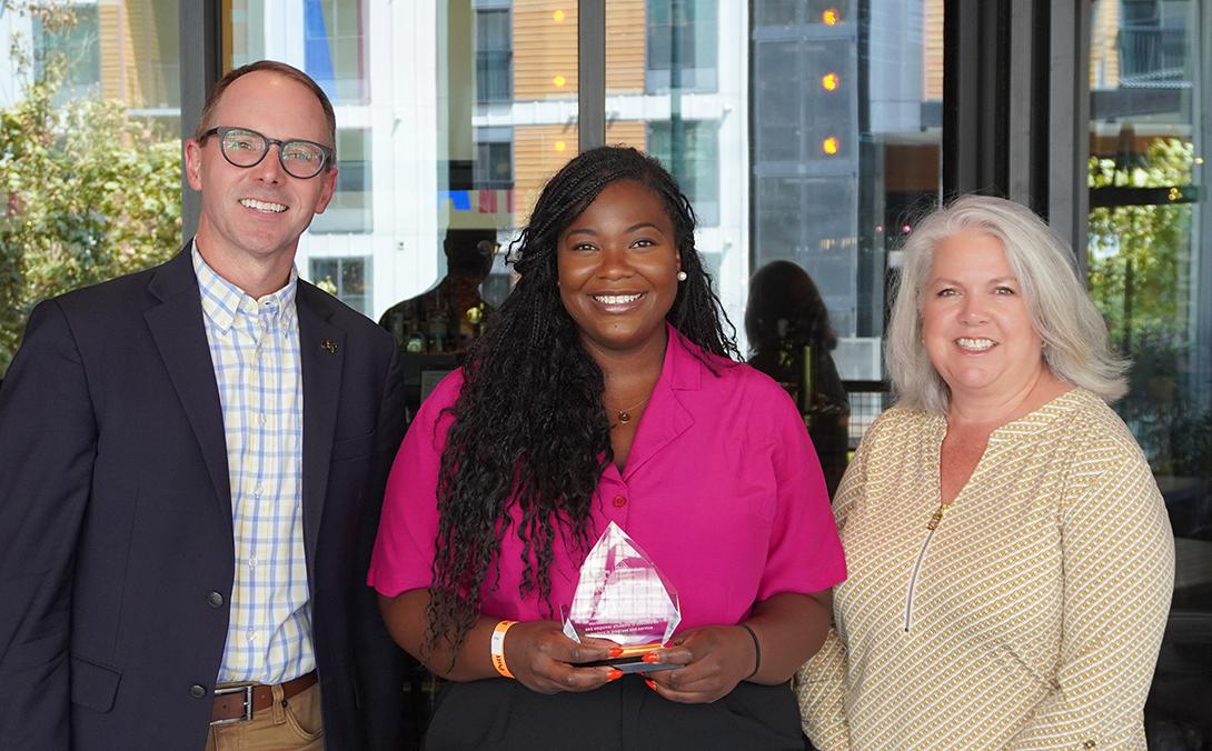 Davia Woulard holds OUE Employee Excellence Award with Vice Provost Steven Girardot and Chair of the Employee Engagement and Culture Committee Kristi Hesse